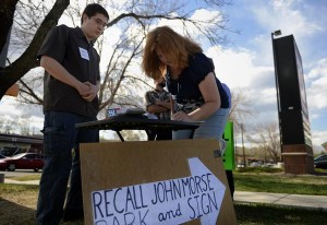 Andy Shank, a volunteer helping to gather signatures to recall state Senate President John Morse, watches Dana Beasley sign a petition at the corner of West Uintah and North 19th streets in Colorado Springs on Thursday. Morse, a Democrat representing Senate District 11, is term-limited in 2014. "I don't like what went on in the legislature in Denver, " Beasley said. (Joe Amon, The Denver Post)